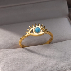 Macro shot of evil eye ring with turquoise stone and golden twisted rope band in jewelry box