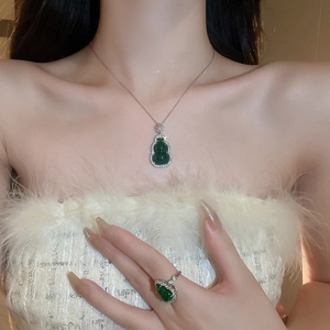 Detail of green resin gourd pendant necklace and ring with cubic zirconia on model