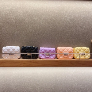 Fila de mini bolsos de gelatina en cinco colores con diseño acolchado y cierre metal