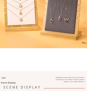 Detail view of gold necklaces with crystals and pearls on a minimalist bamboo jewelry stand