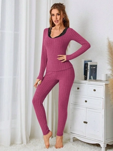 Detail of pink ribbed thermal loungewear set featuring black lace trim on the neckline