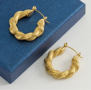 Detailed view of 18k gold plated twisted hoop earrings with a textured spiral finish
