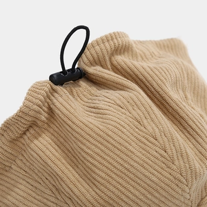 Detail of khaki corduroy fabric featuring an adjustable drawstring and black toggle button