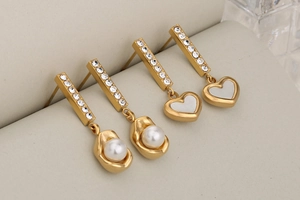 Macro shot of gold-plated heart and pearl earrings with sparkling diamond accents
