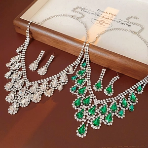 Detailed view of silver luxury teardrop crystal jewelry set on elegant red silk surface