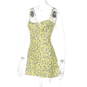 Detalle de vestido corto amarillo con estampado de flores azules y tirantes finos
