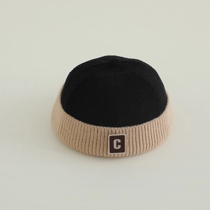 Close-up of knit docker hat featuring a two-tone design with letter C patch detail