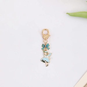 Detail of fairy keychain with blue dress and heart lobster clasp on white background