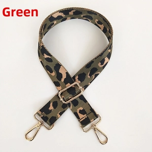 Detail of adjustable leopard print bag strap with golden metal hooks and green pattern