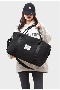Detail of black quilted yoga bag with wide adjustable shoulder strap and handle