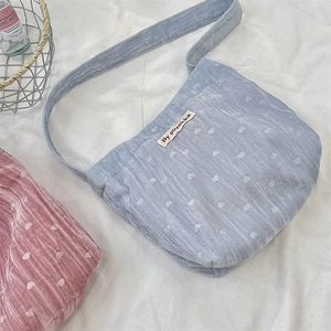 Détail de sacs à bandoulière en velours côtelé avec motifs de cœurs et étiquette tissée