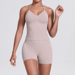 Close-up of pink seamless ribbed yoga set with halter v-neck top and high waist shorts