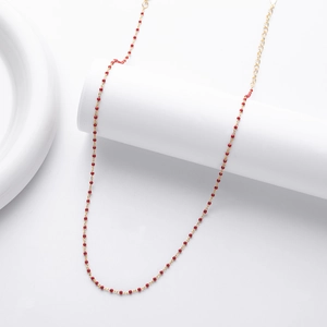 Detail of s925 silver necklace with red beads on a golden chain with extender