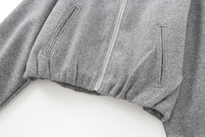 Detail of grey pilot jacket featuring a silver metal zipper and wool blend texture