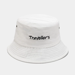 Close-up of white cotton bucket hat featuring black Traveller's embroidery and metal eyelets