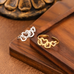 Irregular hollow heart open rings in gold and silver finish on a vintage wooden surface
