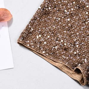 Gros plan détaillé de paillettes dorées café scintillantes sur tissu mesh pour short festif