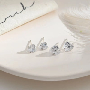 Group of minimalist 3mm heart-shaped sterling silver stud earrings with clear crystals.