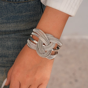 Macro detail of silver layered braided chain bracelet with intricate metallic textures