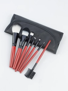 Detail view of 7-piece makeup brush set with mahogany handles and black leather travel pouch