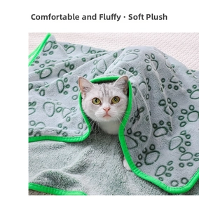 Close-up of fluffy grey flannel pet blanket with paw prints and cozy cat wrapping