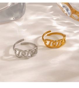 Detail of adjustable gold and silver chain rings on white textured background