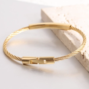 Makro-Detailansicht des goldenen Seilarmbands mit poliertem Metallsteg und Steckverschluss