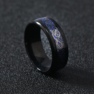 Close-up of men's black stainless steel ring with blue dragon inlay and polished finish