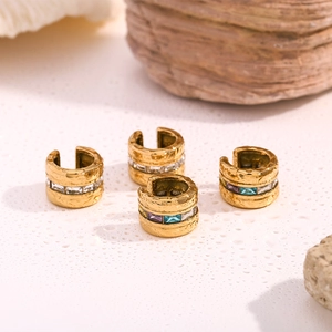 Close-up of gold-plated ear cuffs with hammered texture and colorful zircon stones
