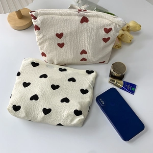 Detail of heart print cosmetic bag in textured bubble cotton with secure zipper closure