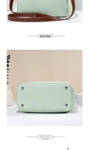 Detail view of mint green bucket bag showing back panel and bottom metal feet studs