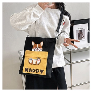 Detail of canvas crossbody bag with yellow pocket featuring a cartoon Corgi and HAPPY print
