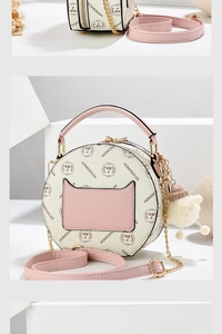 Detail of multi-layer round crossbody bag in cream and pink with gold chain and pom pom