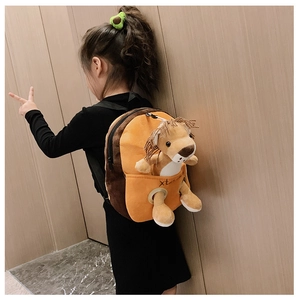 Close-up of cute lion plush toy detail on a brown children backpack with side strap view