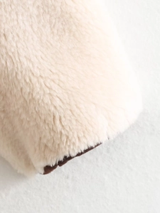 Macro view showing cream faux shearling texture with dark brown fleece inner lining