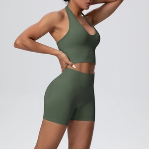 Side view of an olive green seamless ribbed yoga set with halter neck top and high waist shorts