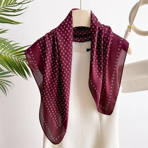 Deep red silk-like square scarf with white paisley print styled on a white top