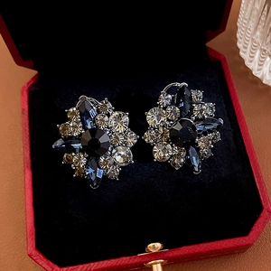 Macro shot of blue flower crystal earrings inside a red velvet jewelry gift box