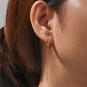 Close-up of elegant gold long chain drop earrings with water drop geometric design