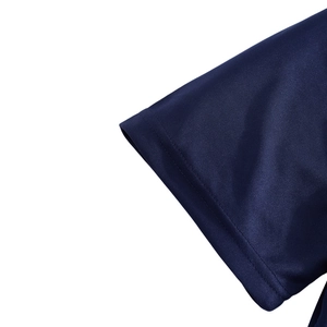 Close-up of navy blue polo shirt sleeve cuff showing breathable mesh pique fabric texture