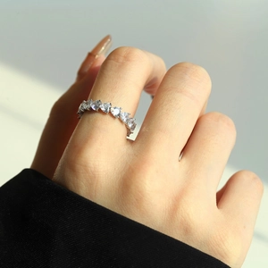 Macro shot of a model wearing a S925 silver eternity ring with heart-cut zirconia