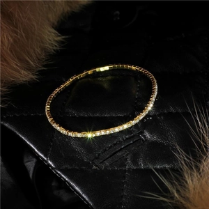 Close-up of 2.0mm gold rhinestone stretch bracelet on black leather and fur background