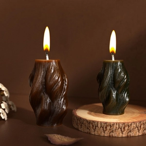 Artistic rotating wave pillar candles in brown and olive green with organic spiral texture