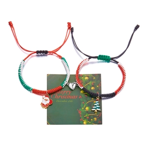 Christmas woven magnetic couple bracelets with Santa and tree charms on a green card
