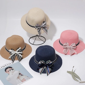 Detailed straw sun hats with ribbons and pearls in beige, brown, navy, and pink tones