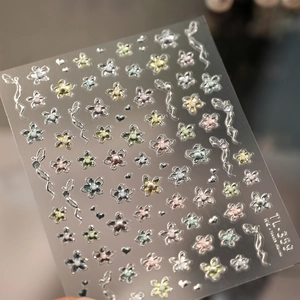 Detail of floral nail art stickers with 3D pearls and silver waves on transparent backing