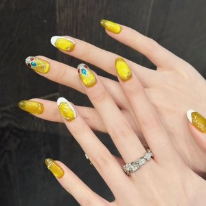 Golden cat eye press-on nails with rhinestone accents and French tip on hands