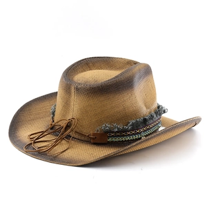 Dettaglio cappello cowboy in paglia con sfumatura vintage e fascia in stile etnico