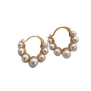 Elegant gold hoop earrings with gradient white pearls on white background