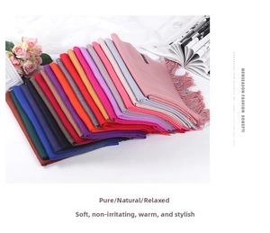 Detail shot of folded colorful cashmere-feel scarves with soft fringes on white desk